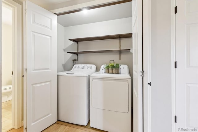 washroom featuring washer and dryer, light wood-type flooring, and laundry area