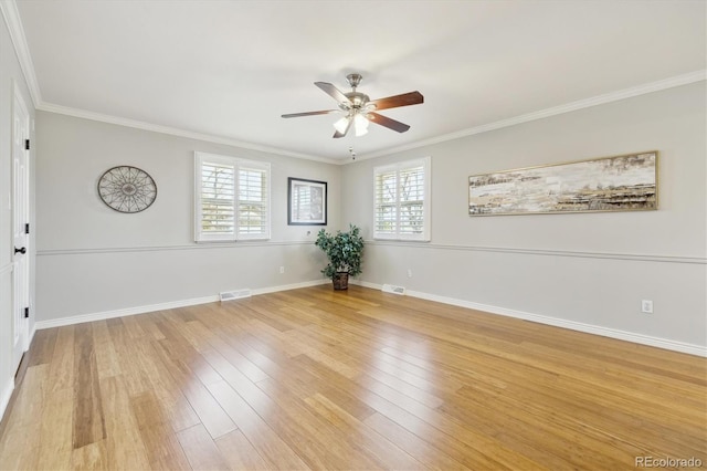 spare room featuring light wood finished floors, visible vents, and crown molding