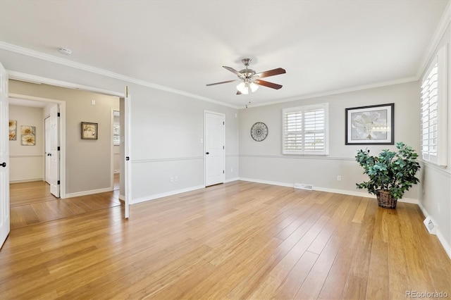 spare room with light wood-style floors, visible vents, and ornamental molding