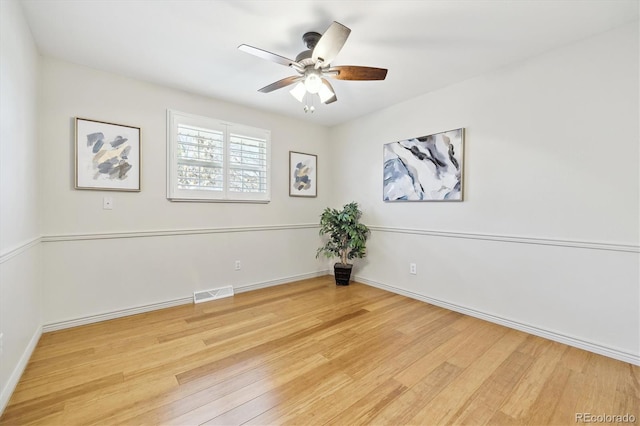 empty room featuring visible vents, baseboards, wood finished floors, and a ceiling fan