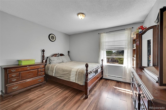 bedroom featuring dark wood-type flooring, a baseboard radiator, and a textured ceiling