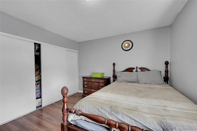 bedroom with a closet, a textured ceiling, and hardwood / wood-style flooring