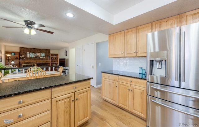 kitchen with a textured ceiling, stainless steel fridge with ice dispenser, decorative backsplash, light brown cabinetry, and light wood finished floors