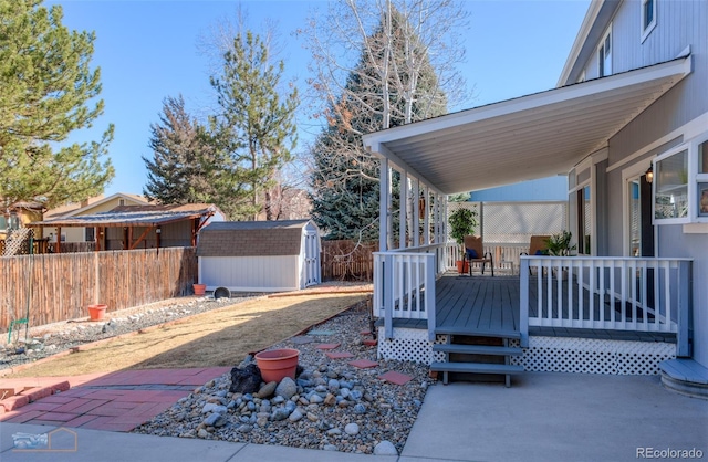 view of patio / terrace featuring fence, an outdoor structure, and a shed