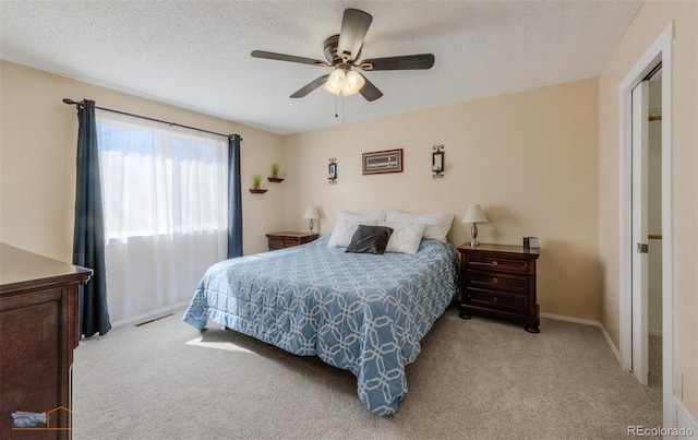 bedroom featuring a textured ceiling, carpet, visible vents, and a ceiling fan