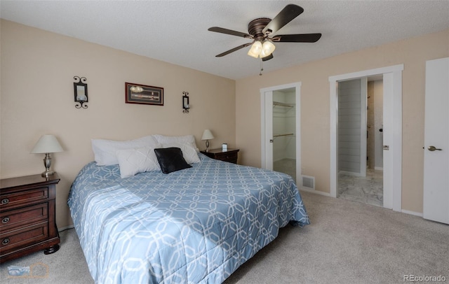 bedroom with a ceiling fan, a textured ceiling, visible vents, and carpet flooring