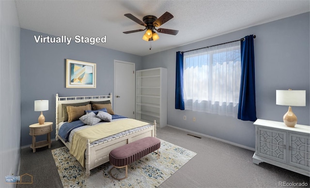 carpeted bedroom featuring baseboards, visible vents, ceiling fan, and a textured ceiling