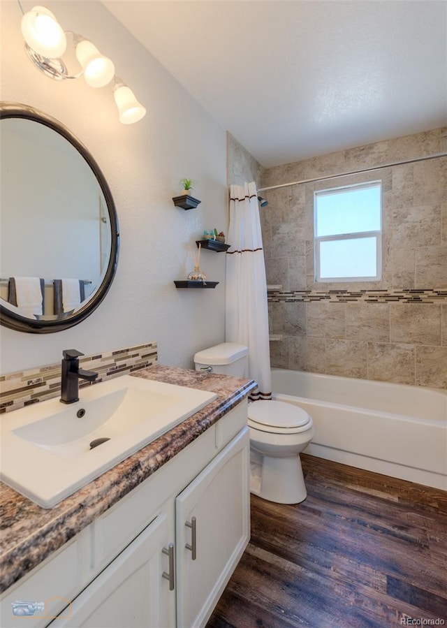 full bathroom with shower / tub combo with curtain, tasteful backsplash, toilet, vanity, and wood finished floors