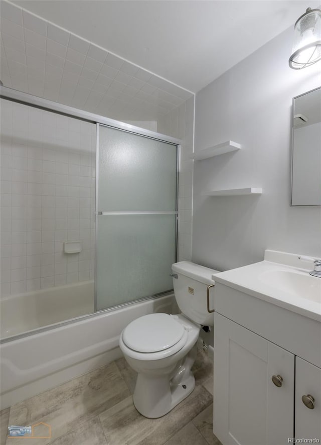 full bathroom with toilet, combined bath / shower with glass door, and vanity