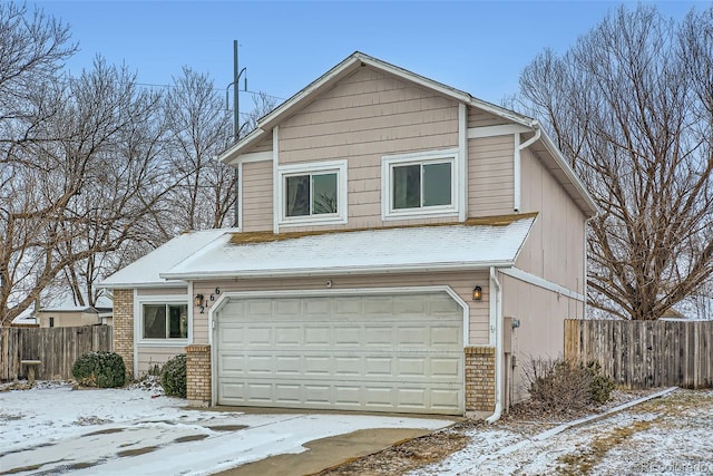 view of front of property featuring brick siding, an attached garage, and fence