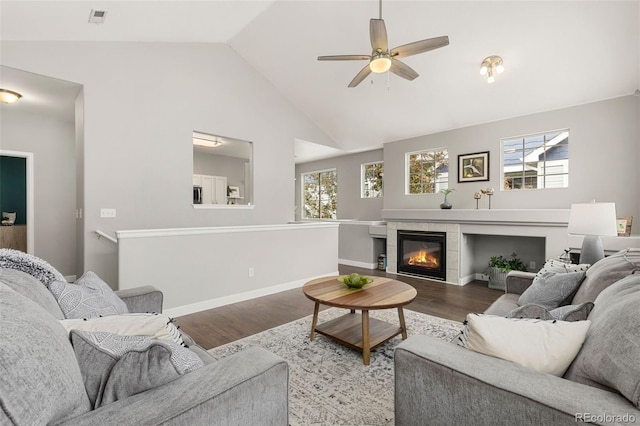 living room with baseboards, ceiling fan, wood finished floors, and a fireplace