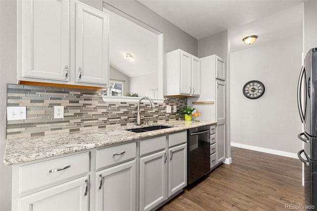 kitchen featuring appliances with stainless steel finishes, a sink, baseboards, tasteful backsplash, and dark wood-style floors