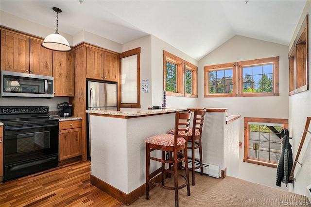 8305 Northstar Unit 8-305, Granby, CO 80446 - kitchen with appliances with stainless steel finishes, brown cabinetry, a breakfast bar, a baseboard radiator, and vaulted ceiling