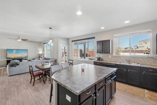 kitchen with a center island, backsplash, a healthy amount of sunlight, and sink