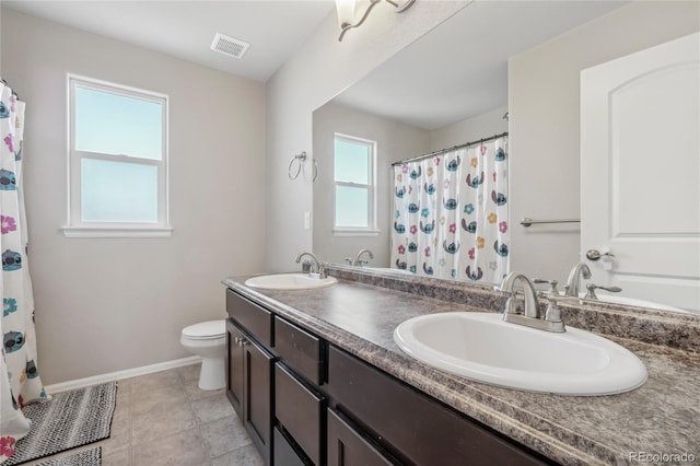 bathroom with tile patterned flooring, vanity, and toilet