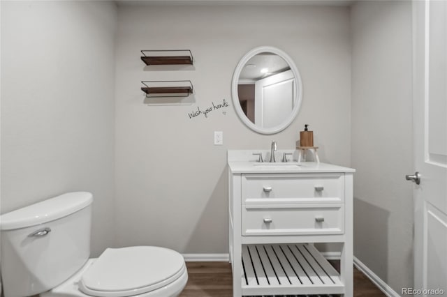 bathroom featuring wood-type flooring, vanity, and toilet