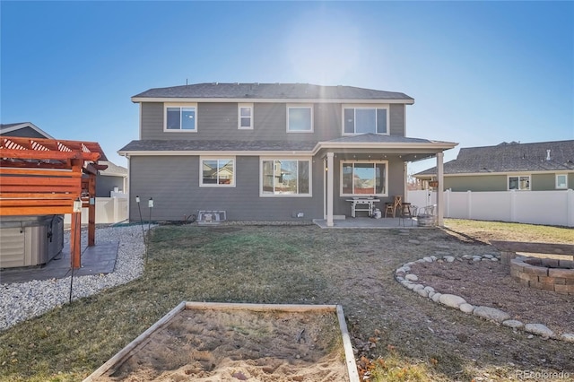 back of house with a lawn and a patio