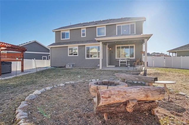 back of house with an outdoor fire pit and a patio