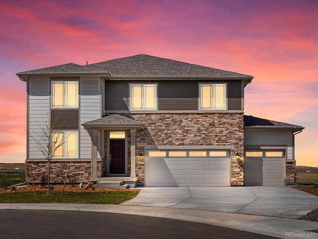 prairie-style house featuring concrete driveway, a shingled roof, stone siding, and a garage