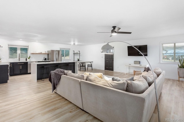 living room with ceiling fan and light hardwood / wood-style flooring