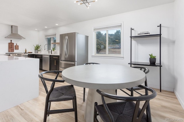 dining room with light wood-type flooring, an inviting chandelier, baseboards, and recessed lighting