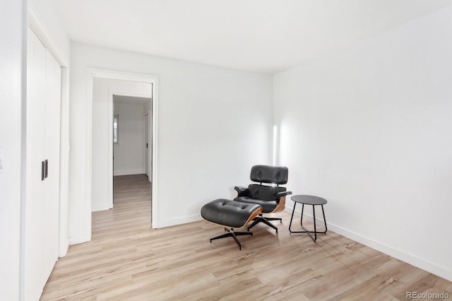 living area featuring light wood finished floors and baseboards