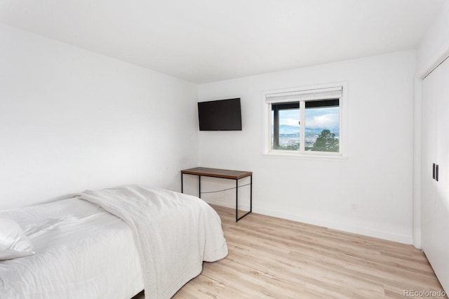 bedroom featuring light wood-type flooring and baseboards