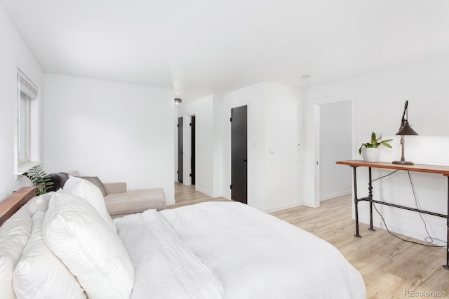 bedroom with light wood-type flooring and baseboards