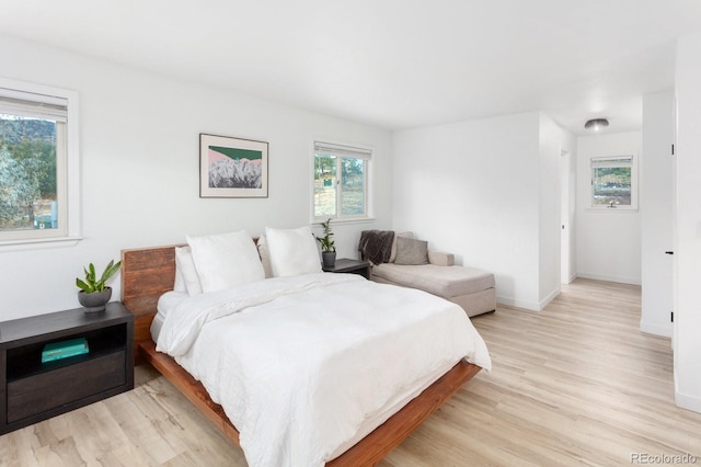 bedroom with light wood finished floors and baseboards