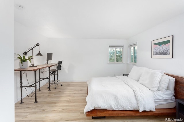 bedroom with baseboards and wood finished floors