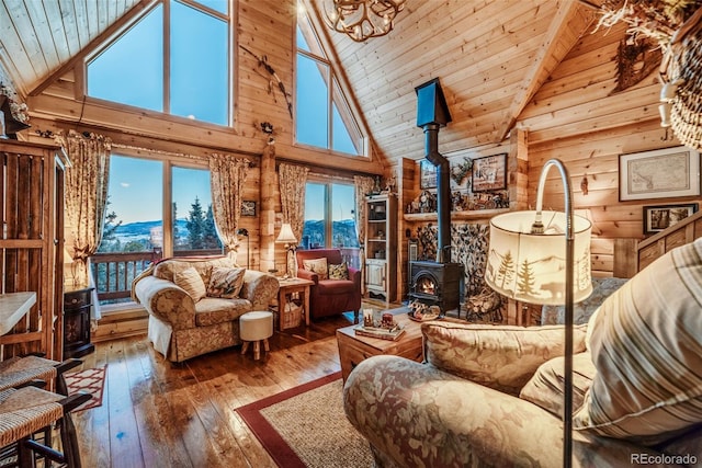 sitting room with wood ceiling, vaulted ceiling, wood-type flooring, and a wood stove