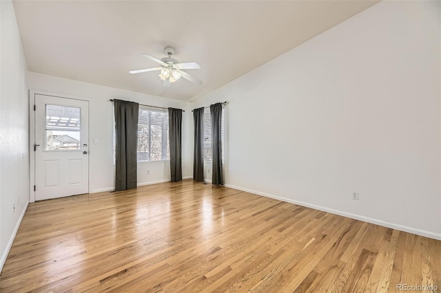 unfurnished room featuring light wood-type flooring, baseboards, a ceiling fan, and lofted ceiling