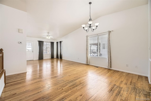 spare room with vaulted ceiling, light wood finished floors, ceiling fan with notable chandelier, and baseboards