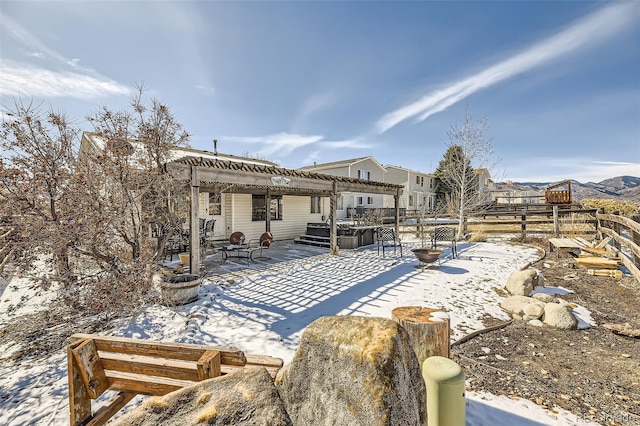 snow covered house featuring a patio area, fence, and a pergola