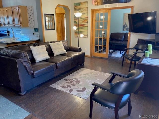 living room with french doors, dark hardwood / wood-style flooring, and sink