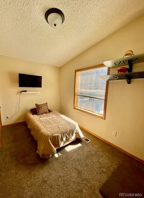 unfurnished bedroom with a textured ceiling, carpet floors, and vaulted ceiling