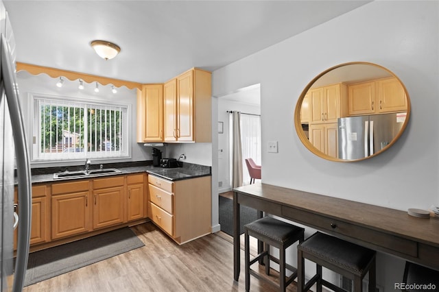 283 Leonard Ln, Northglenn, CO 80233 - kitchen with freestanding refrigerator, stainless steel refrigerator, light wood-style floors, light brown cabinetry, and dark countertops