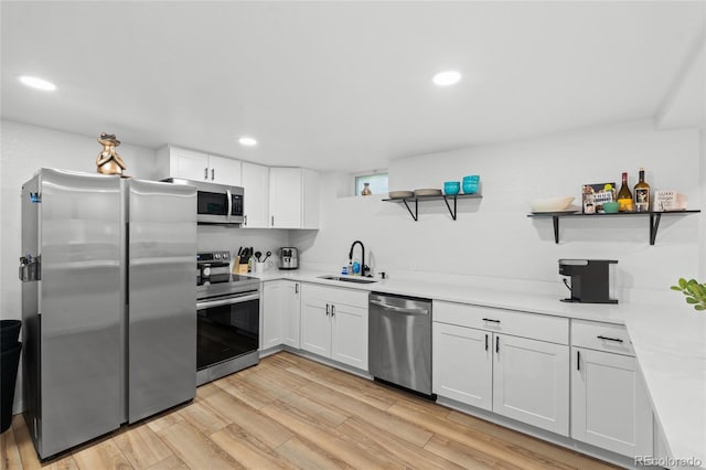 283 Leonard Ln, Northglenn, CO 80233 - kitchen featuring appliances with stainless steel finishes, open shelves, white cabinetry, light countertops, and light wood-type flooring