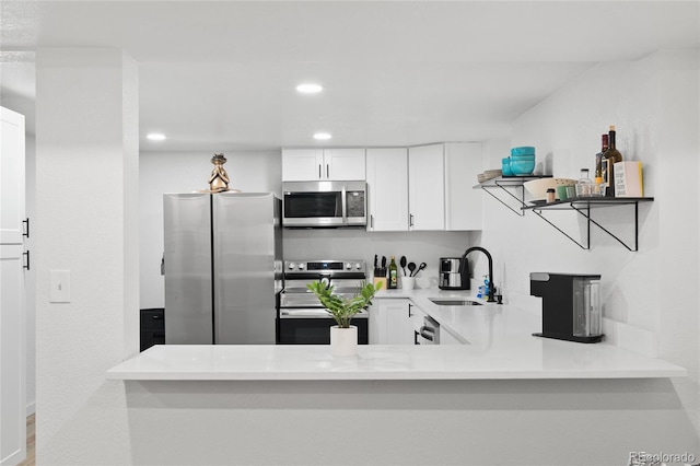283 Leonard Ln, Northglenn, CO 80233 - kitchen with stainless steel appliances, light countertops, white cabinets, recessed lighting, and open shelves