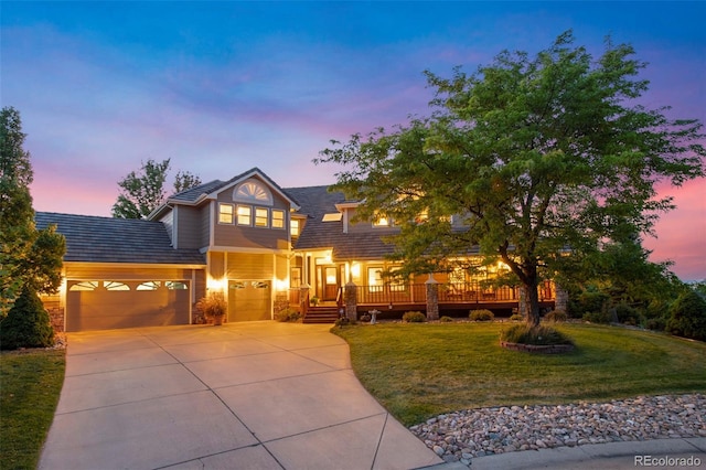 view of front of property with a garage and a lawn