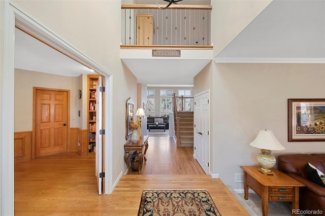 entrance foyer with ornamental molding and light hardwood / wood-style flooring