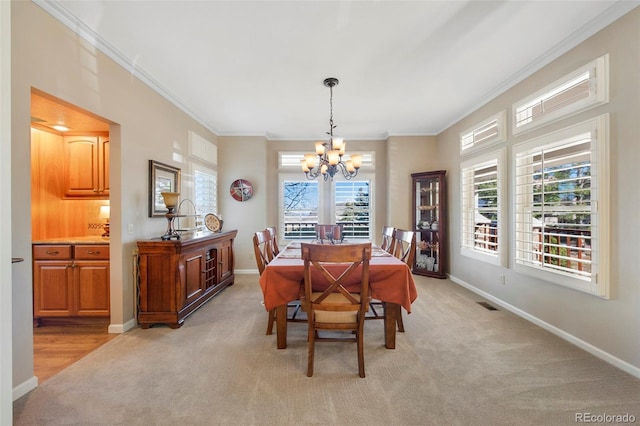 carpeted dining room with an inviting chandelier and ornamental molding