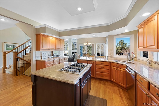 kitchen featuring an inviting chandelier, sink, decorative backsplash, a kitchen island, and stainless steel appliances