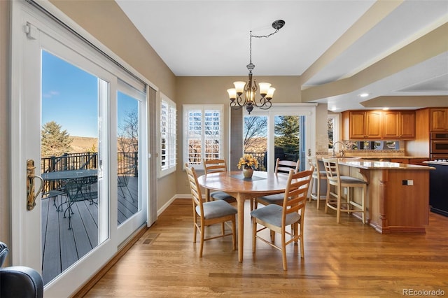 dining space with a chandelier and light hardwood / wood-style floors