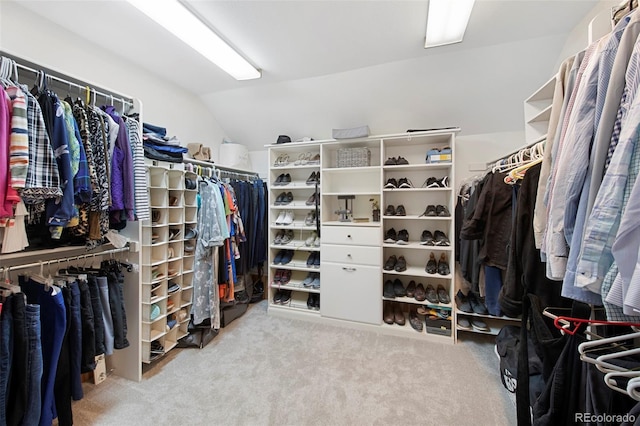 walk in closet featuring light carpet and lofted ceiling