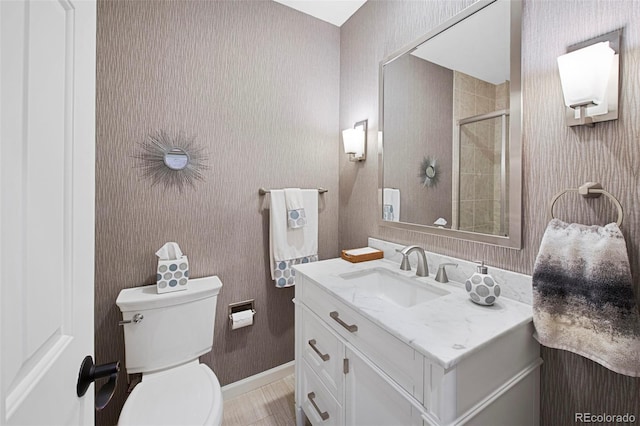 bathroom featuring vanity, toilet, and walk in shower