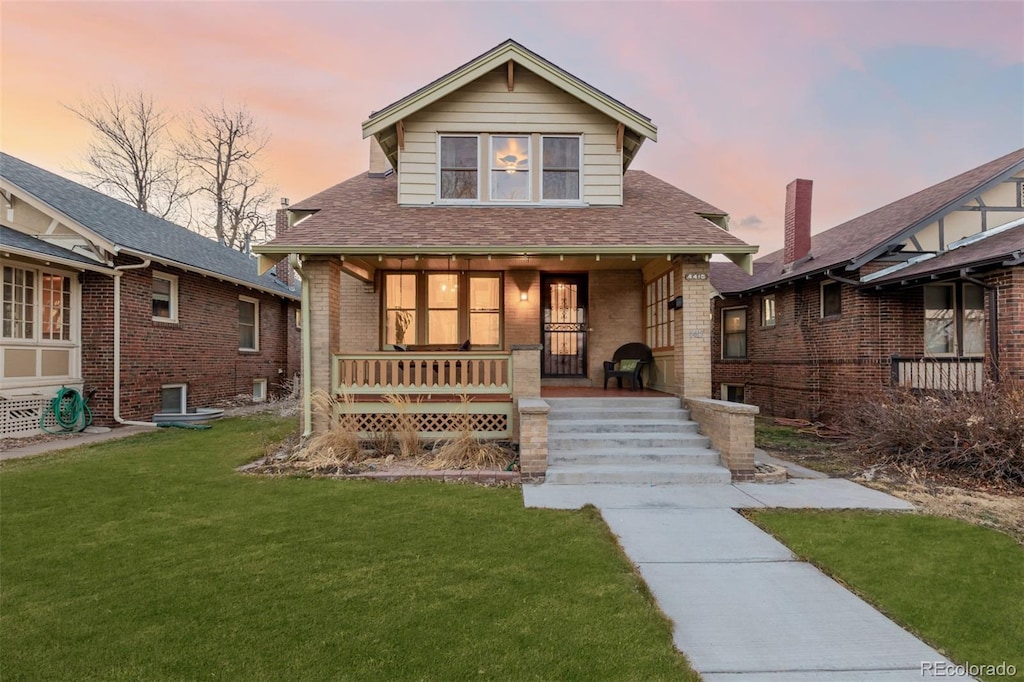 bungalow with a porch and a yard