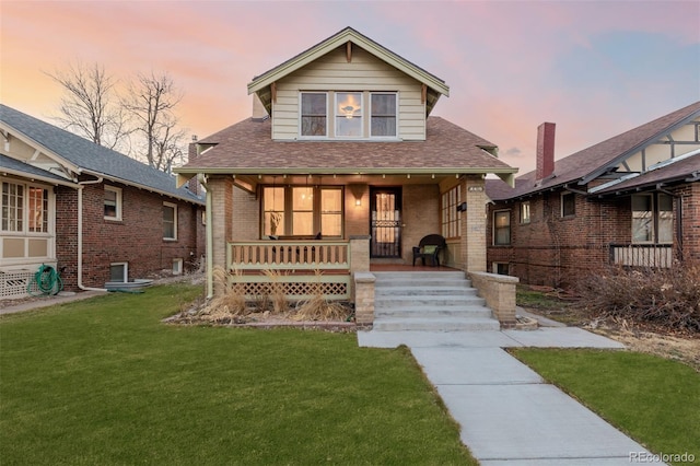 bungalow with a porch and a yard