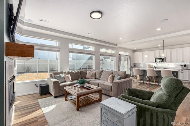 4104 N Picadilly Ct, Aurora, CO 80019 - living room featuring light wood-style floors and recessed lighting