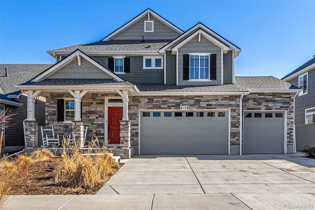 4104 N Picadilly Ct, Aurora, CO 80019 - craftsman house with driveway, covered porch, stone siding, a shingled roof, and a garage